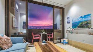 Cozy living room and terrace at Distrito Centro 602 with sunset skies and views of downtown Cozumel life below