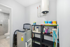 Practical laundry and storage area with washer and water heater at Sophie’s Loft in Cozumel